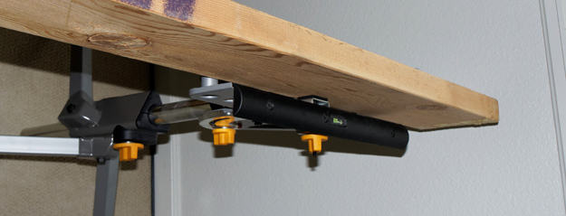 Photograph of 2 x 6 held by a Rockwell JawStand for Peter Free article showing how to use the stands to make an adjustable height desk.